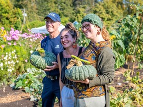Giving Garden Harvest Fall 2022 event at Royal Roads University near Victoria. Left to right: University president Philip Steenkamp, Jesse Willis of Upbeet Garden and Anna Maria Stone of Iyé Creative. Steenkamp and Stone hold a variety of winter squash to be donated to local community groups.