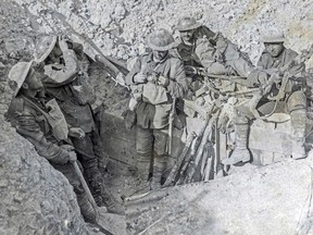Canadian soldiers in a captured German trench during the Battle of Hill 70 in August 1917. The soldiers on the left are scanning the sky for planes, while the soldier in the center appears to be repacking his gas respirator on the transport bag of his thorax.  Dust covers his clothes, helmets and weapons.