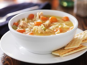 A hot bowl of chicken noodle soup with crackers.