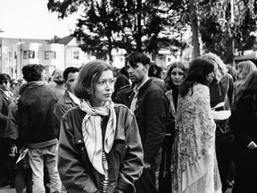 Writer Joan Didion walks among hippies during a gathering in Golden Gate Park, San Francisco.
