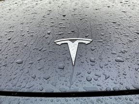 The Tesla logo on one of its rain-spattered vehicles.