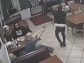 A man, whose identity has not been released, aims his gun a moment before fatally shooting Eric Eugene Washington, who was robbing a Houston restaurant.