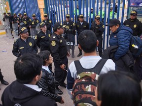 Policemen stand guard at the entrance of the international airport in Cusco after it was closed for security reasons on January 12, 2023, as riots persisted in the city. - The international airport of the city of Cusco, a mecca of world tourism for Machu Picchu, suspended its operations indefinitely to prevent attacks by protesters calling for the resignation of Peruvian President Dina Boluarte, the government announced Thursday. (Photo by Ivan Flores / AFP)