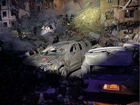 This handout picture taken and released by the Ukrainian Emergency Service on January 14, 2023, shows rescuers working on a residential building destroyed after a missile strike, in Dnipro. - A strike on a residential building in the eastern Ukrainian city of Dnipro on January 14, 2023, left at least five dead and 27 injured, officials said. (Photo by Handout / UKRAINIAN EMERGENCY SERVICE / AFP)
