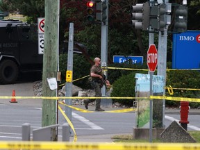 Police respond to gunfire at the Bank of Montreal in Saanich, B.C., on Tuesday, June 28, 2022. Police will release the results of their investigation into the dramatic shootout in which two gunmen were killed outside the bank.