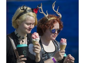 2019. L-R. Camille Dinesen and Lilya Mansfield enjoy some cold treats at the 42nd annual Vancouver Folk Festival at Jericho Beach, Vancouver, July 19 2019.
