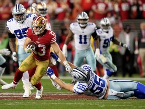 San Francisco 49ers running back Christian McCaffrey evades a sprawled-out Leighton Vander Esch, linebacker for the Dallas Cowboys,  during their NFC Divisional playoff game at Levi's Stadium in Santa Clara, Calif., on Jan. 22, 2023.