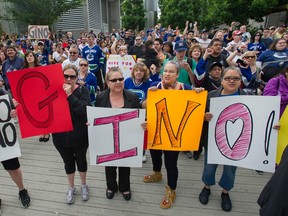 Supporters raise the spirits of ailing former Vancouver Canuck Gino Odjick as they rally outside Vancouver General Hospital on June 29, 2014.