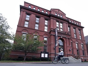 A cyclist rolls past the Peabody Museum of Archaeology & Ethnology at Harvard University in Cambridge, Mass., on October 13, 2016. After 138 years, including two decades in storage, a house post will be returned to a First Naiton in British Columbia from Harvard University. The house post was bought by a fishing company in 1885 and has been part of the museum's anthropological artifacts since 1917.