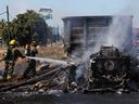 Firefighters extinguish the fire of a vehicle set on fire by members of a drug gang as a barricade, following the detention by Mexican authorities of drug gang leader Ovidio Guzman in Culiacan, a son of imprisoned kingpin Joaquin (El Chapo) Guzman, in Mazatlán, Mexico on Jan. 5, 2023.