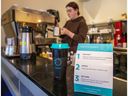 Signalisation autour du programme de partage de tasses au Continental Coffee House où le barista Elie Petit prépare une boisson.