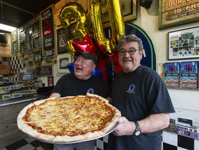 Franco (left) and Nat Bastone with one of their pizzas at the popular West Broadway pizzeria, Nat’s New York Pizzeria last April 30.