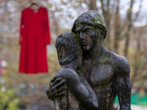 A red dress behind a statue at Vancouver City Hall on May 5, 2022. The city marked the National Day of Awareness for Missing and Murdered Indigenous Women, Girls and Two-Spirit (MMIWG2S) with a special ceremony. Red dresses are hung in trees to commemorate the missing and murdered.