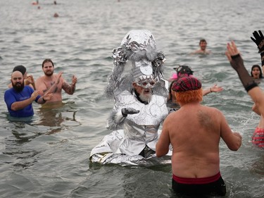 A person dressed in a costume participates in the Polar Bear Swim at English Bay, in Vancouver, B.C., Sunday, Jan. 1, 2023.