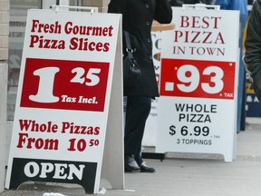 Archival photo from 2004 showing two pizza joints side by side in Downtown Vancouver advertising cheap slices.