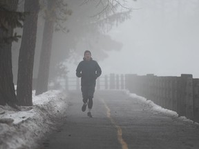 A person jogs along the Rideau Canal in Ottawa, on Saturday, Dec. 31, 2022. One extreme weather expert says the current spell of mild winter temperatures felt in Ontario are becoming more frequent across Canada due to climate change.