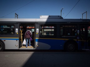 A woman boards a transit bus in Vancouver on Friday, March 20, 2020. The union representing transit bus drivers in B.C.'s Fraser Valley has given a 72-hour strike notice and could stop collecting fares as early as Thursday. The union says members make 32 per cent less than transit workers across the Lower Mainland, with no pension plan and long hours of standby time for which they receive less than $3 per hour.
