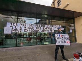 Protesters are seen outside the retirement home of Johannes Rivoire in Lyon, France on Monday Jan.16, 2023. A group of activists are calling on France to extradite the retired priest to Canada to face allegations that he sexually abused Inuit children in Nunavut more than three decades ago.
