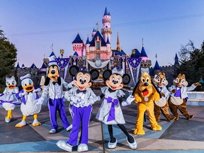 Mickey Mouse, his pals pose in front of Sleeping Beauty Castle in Disneyland Resort.