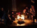 Earthquake survivors spend the night outdoors around a fire in winter weather after homes were toppled by Monday earthquake, in Iskenderun, Turkey.