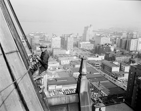 John McGinnis photo of steelworker Jack McGregor repairing the roof of the Hotel Vancouver, Sept. 6, 1955. The view looks northeast over downtown Vancouver toward Burrard Inlet. It appeared on the front of the Sept. 7, 1955 Vancouver News-Herald.