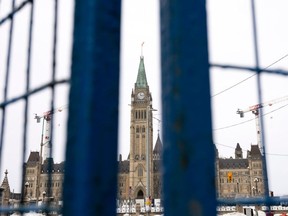 The Peace tower is seen between panels of temporary fencing, Wednesday, Feb. 23, 2022 in Ottawa.
