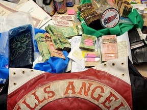 Items seized during a 13-month police investigation dubbed Project Coyote -- including drugs, guns, ammo, cash and outlaw motorcycle gangs colours of Hells Angels and Red Devils MC puppet gang members -- are displayed in images released by the OPP on Wednesday, Feb. 22, 2023.