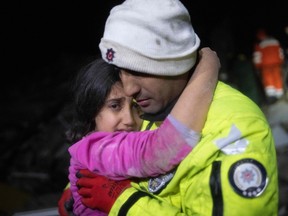 Police officer Zekeriya Yildiz hugs his daughter after they saved her from the rubble in Hatay on Feb. 6, 2023, after a 7.8-magnitude earthquake struck the country's south-east.