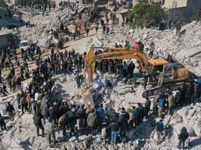 Rescuers search for survivors amidst the rubble of a collapsed building in the town of Harim in Syria's rebel-held northwestern Idlib province on the border with Turkey.