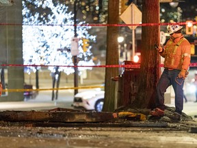 A hydro worker takes a photo of an underground electrical vault after a fire and explosion in downtown Vancouver on Friday.