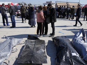 People mourn over the bodies of earthquake victims outside a hospital in Antakya, southeastern Turkey, Thursday, Feb. 9, 2023.