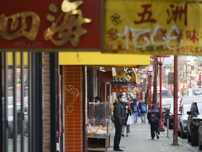 People shop in Chinatown in Vancouver on Friday, February 5, 2021. Police say they've arrested a suspect in a spate of vandalism incidents in Chinatown.