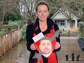 Linda Annis, executive director of Metro Vancouver CrimeStoppers, holds a Valentine's Day heart bearing the face of killer and prison escapee Rabih Alkhalil at an event highlighting six of B.C.'s most wanted fugitives.
