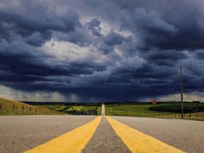 Storm clouds build over a highway in southern Alberta near the town of Carstairs on Monday, July 4, 2016. A Winnipeg man is trying to launch a class-action lawsuit against the Manitoba government, alleging it overcharged people an estimated $36 million in photo radar tickets.