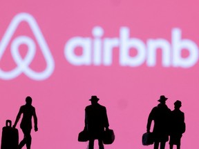 Figures are seen in front of the Airbnb logo in this illustration taken February 27, 2022.