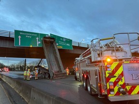 Firefighters clean up after a trailer from a truck slammed into a highway overpass in Richmond, B.C., on Friday, in this RCMP handout image posted on their Twitter feed. The crash before the Knight Street Bridge snarled traffic for hours.
