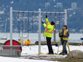 City workers repair damage after vandals cut the swings at the playground at Kitsilano Beach park.