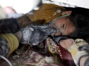 A child is rescued from rubble after an earthquake in Azmarin, Syria, on February 7, 2023 in this still image taken from video.