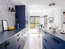 Flat-front cabinetry and a navy-on-navy colour scheme, with unfussy hardware and polished concrete floors, keep the kitchen low maintenance and visually clean. 