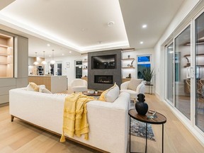 Living room with sofa, side table and gas fireplace with TV.