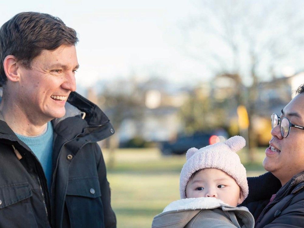 Premier David Eby is seen with a family in an image from a new series of online NDP ads. 