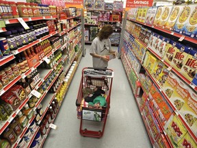 In this Dec. 14, 2010, file photo, a woman shops through the cereal aisle as her daughter catches a short nap in the shopping cart at a store in Waco, Texas.