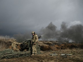 TOPSHOT - Ukrainian servicemen fire with a 105mm howitzer towards Russian positions near the city of Bakhmut, on March 8, 2023, amid the Russian invasion of Ukraine.