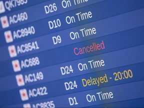 In this file photo taken on March 13, 2019, a screen showing a cancelled Air Canada flight to St. John's International Airport is pictured at Toronto's Pearson International Airport in Mississauga, Ont.