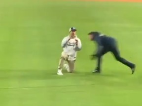 A young man jumped onto the outfield at Dodger Stadium to propose to his girlfriend in the stands, and got flattened by security on MLB's opening day Thursday.