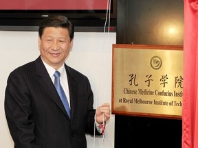 China's then-Vice President Xi Jinping unveils a plaque at the opening of the Chinese Medicine Confucius Institute at the RMIT University in Melbourne in 2010.