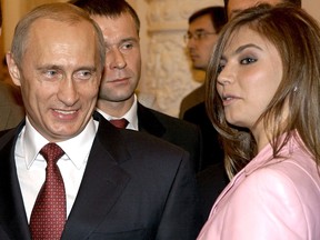 Russian President Vladimir Putin smiles next to Russian gymnast Alina Kabaeva during a meeting with the Russian Olympic team at the Kremlin in Moscow, Russia in this November 4, 2004 file photo.