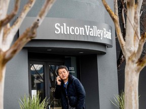 A pedestrian speaks on a mobile telephone as he walks past Silicon Valley Banks headquarters in Santa Clara, California on March 10, 2023. - US authorities swooped in and seized the assets of SVB, a key lender to US startups since the 1980s, after a run on deposits made it no longer tenable for the medium-sized bank to stay afloat on its own. (Photo by NOAH BERGER / AFP)