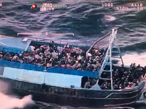 This photo grabbed from an aerial video made available by the Italian Coast Guards on March 11, 2023 shows a boat overloaded with migrants during a Coast Guards rescue operation on March 10, 2023 off the coast of Calabria, southern Italy. - The Italian coast guard and the Italian Navy dispatched several ships on March 10 to rescue 1,300 migrants in the central Mediterranean, the world's most dangerous migration route, less than two weeks after a deadly shipwreck on the country's southern coast. (Photo by Handout / GUARDIA COSTIERA / AFP) /