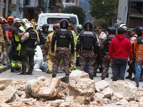 Soldiers and firefighters work at the place where the cornice and terrace of a building located in Cuenca's historic center fell and destroyed a car, leaving one dead and one person injured, after an earthquake in Cuenca, Ecuador on March 18, 2023. - Four dead in southern Ecuador and damage to buildings after an earthquake with an epicenter in that country, which reached its neighbor Peru, according to a preliminary balance of authorities. The earthquake of magnitude 6.5 in Ecuador and 7.0 in Peru was recorded at 12:12 local time (17:12 GMT) in the Ecuadorian municipality of Balao, about 140 kilometers from the port of Guayaquil, and at a depth of 44 kilometers, authorities reported. (Photo by FERNANDO MACHADO / AFP)
